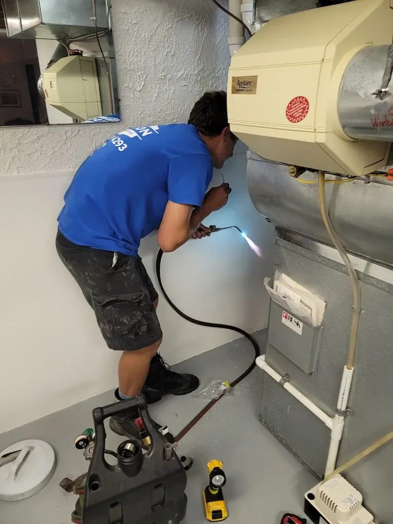 Watson Heating + Cooling technician brazing a line on a furnace install
