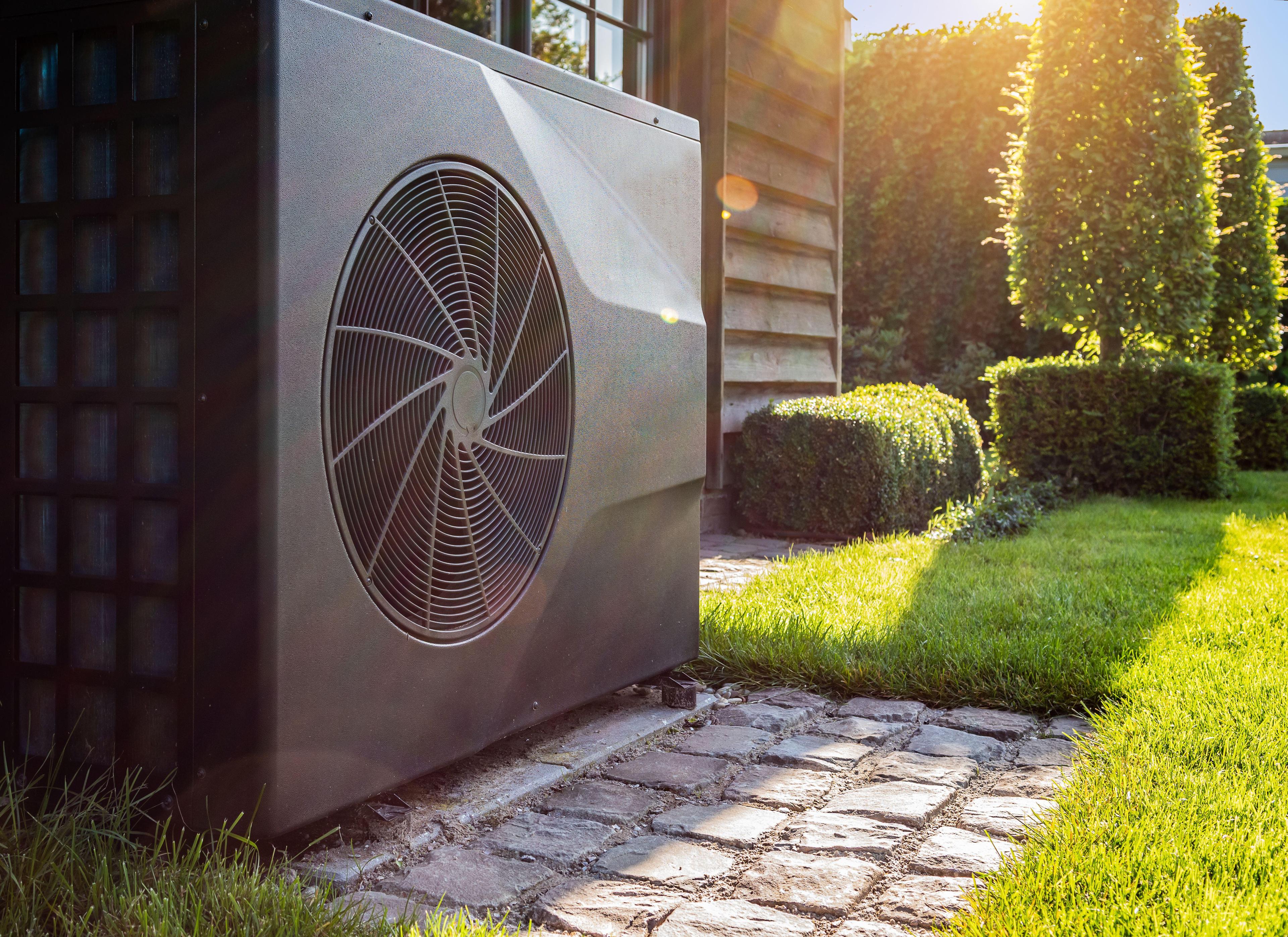 Outdoor heat pump unit installed next to a home exterior